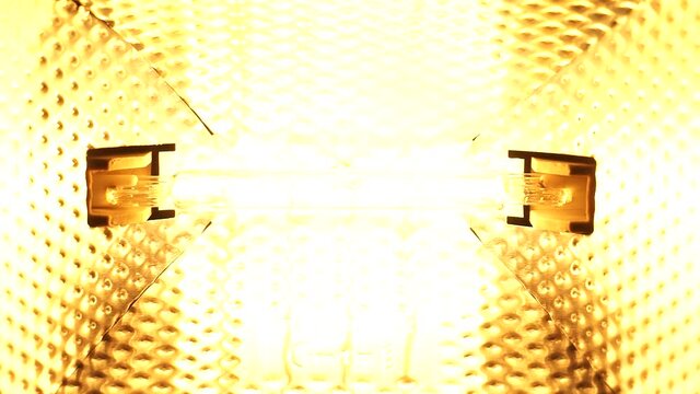Filament halogen floodlight. Smooth increase and decrease in the power of the helix of the halogen floodlight. The tungsten filament.