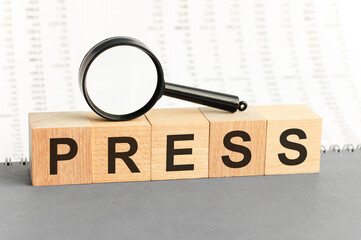 wooden blocks with the text: press with magnifying glass.