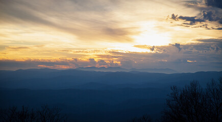Sunset in winter in the Applachain Mountains, vivid sky with orange hues and layers of smoky blue mountains
