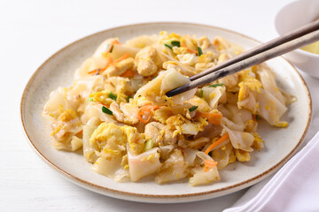 Thai food (Kuaitiao Khua Kai), Stir fried rice noodles with egg and chicken eating with chopsticks