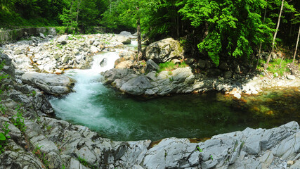 Gilort river rapidly flowing and winding across its craggy valley. The stream forms rapids and...