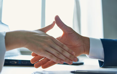 Fototapeta na wymiar employees shaking hands at work in the office agreement document laptop
