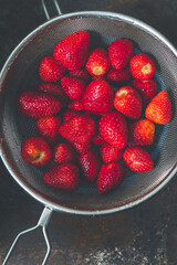 Ripe washed strawberries without stalks in a colander - 401303065