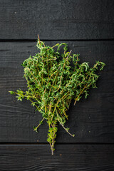 Thyme green bunch, on black wooden background, top view