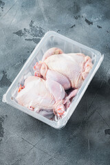 Raw chicken in plastic sealed box, on gray background