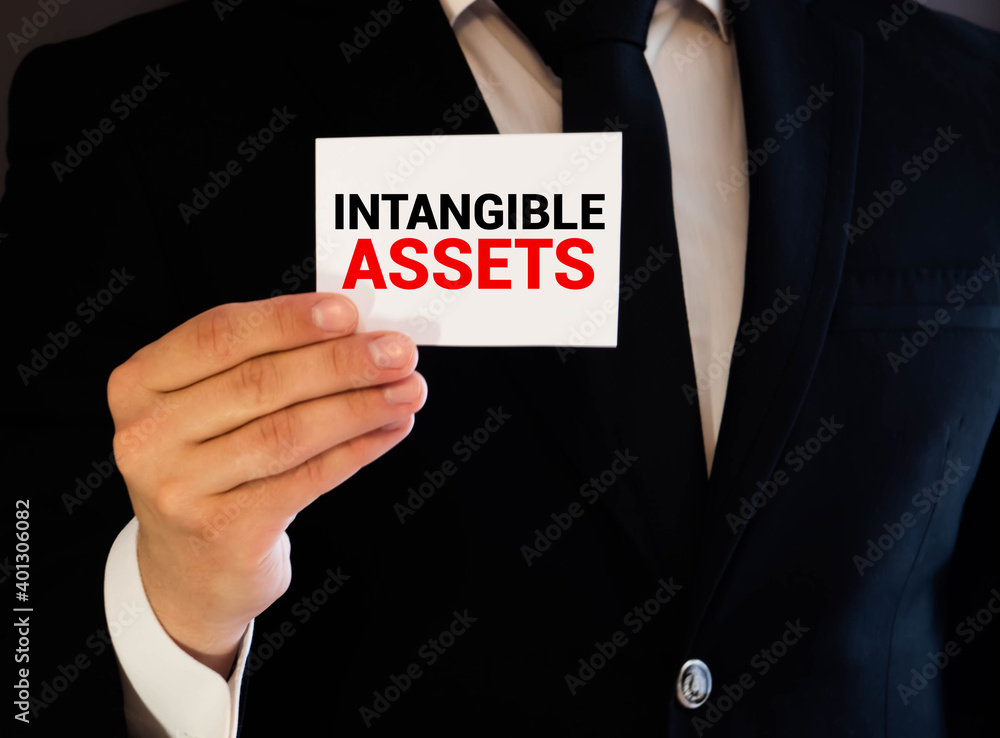 Poster intangible asset text written on a notebook with pencils