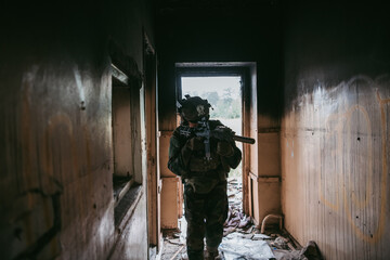 Naklejka na ściany i meble Soldier in combat. Urban combat training, soldier entering abandoned building. Anti terrorist operation battlefield training.