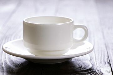 A white coffee cup on a wooden background. Empty coffee cup on a brown wooden table