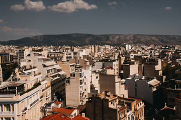 Aerial birds eye shot of lighting downtown of Athens during sunset with mountains in background.