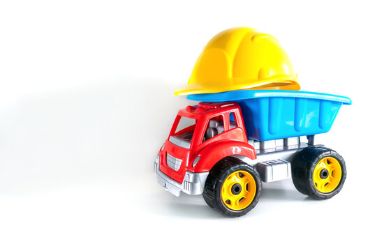 Colorful plastic truck toy with yellow helmet isolated on white background with copy space, toys for children, kids
