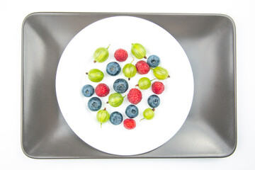 Assorted fresh different berries on a white plate. useful vitamin healthy food fruit. healthy vegetable breakfast