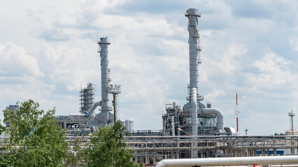 Obraz premium Industrial furnace and heat exchanger cracking hydrocarbons in factory on blue sky background, Close-up of equipment in petrochemical plant. Industry and ecological problem concepts.