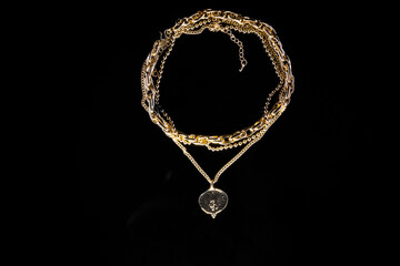 Golden jewelry chain with medallion isolated on black background