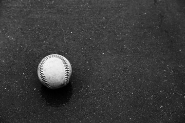 Baseball rain delay concept with ball on wet concrete background.