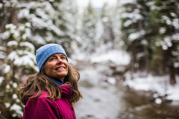A portrait of a woman , in the winter,  near Gore Creek in Vail, Colorado, USA - obrazy, fototapety, plakaty
