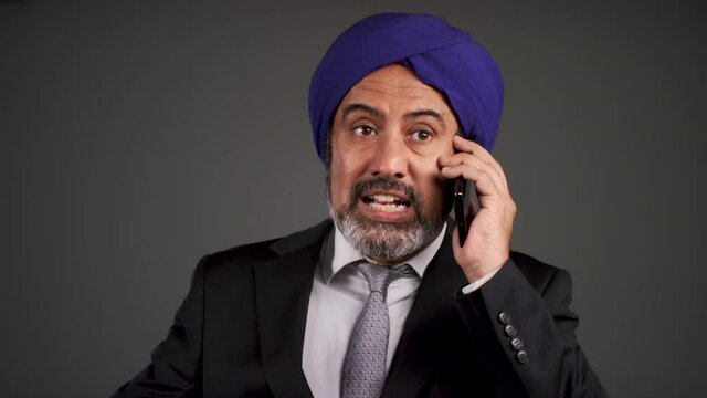 Annoyed Middle Aged Businessman In Turban Shouting On Phone
