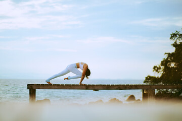 woman doing yoga at island beach pier