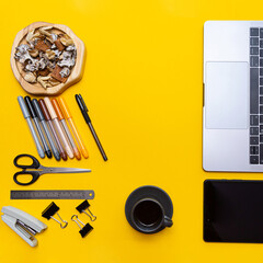 Workplace. Laptop, tablet, espresso cup and stationery flat lay on yellow background with copy space
