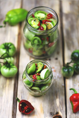Selective focus. Jars of fermented green tomatoes. Pickling green tomatoes. Probiotics and fetmented foods.