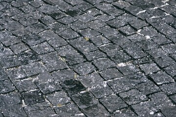 Close up cobblestone pavement in winter time. Textured, surface.