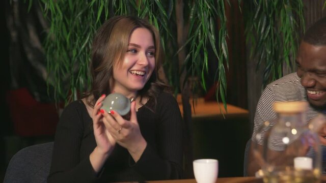 Young woman examines the ceramic chinese tea frog in chinese tea cafe