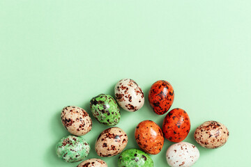 Colorful Easter Quail eggs on light green. Spring Easter small spotted egg