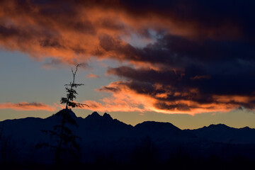 Obraz na płótnie Canvas Colorful, cloudy sunrise over Alaska's Chugach Range