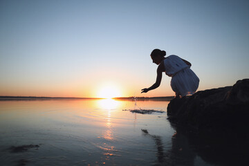 Woman near river on sunset. Healing concept