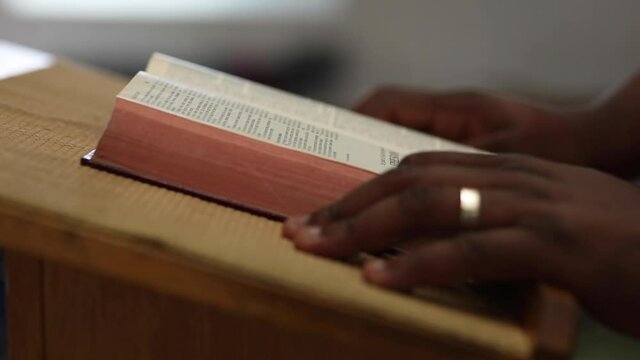 African American Prepares To Preach With Bible On Pulpit Close Up