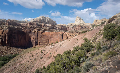 Golden sandstone geographical formations with a desert prairie landscape on a hot summer day at the Cohan Canyon Trail in Capitol Reef National Park Southern Utah.
