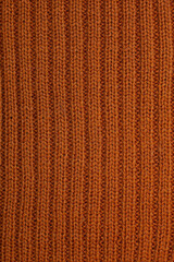 Wool knitting fabric in mustard, ribs, handmaid, needlwork. Clousup. Vertical photo