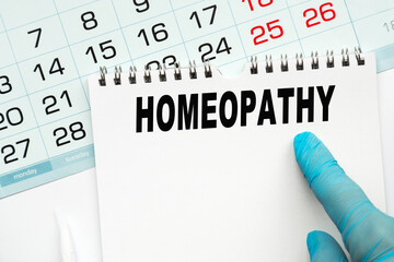 The doctor points to the text HOMEOPATHY, medical concept