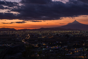 Ciudad de puebla al anochecer con el volcan popocatepetl de fondo 