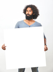 Cheerful bearded young man holding white board on white background.