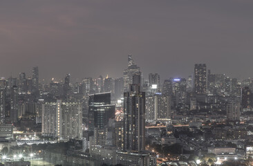 Naklejka premium Bangkok, thailand - Dec 23, 2020 : Bangkok downtown cityscape in Business district with bright glowing lights at night give the city a modern style. Dark tone, No focus, specifically.