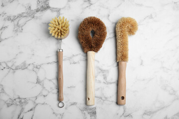 Cleaning brushes for dish washing on white marble table, flat lay