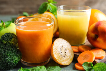 Glasses of delicious juices and fresh ingredients on table, closeup
