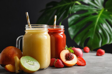 Delicious juices and fresh ingredients on grey table