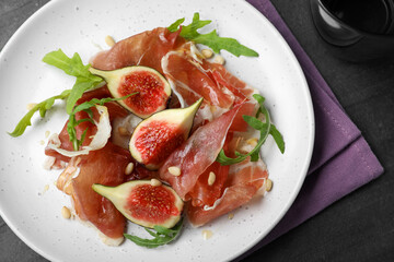 Delicious figs and proscuitto on plate, flat lay