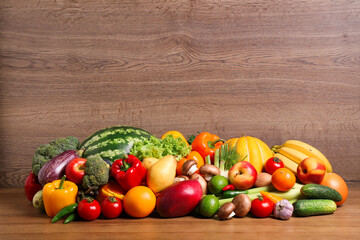 Assortment of fresh organic fruits and vegetables on wooden table. Space for text
