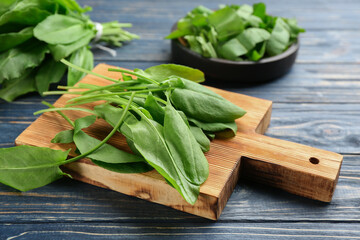 Fresh green sorrel leaves on blue wooden table, closeup