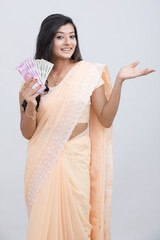 Happy Indian traditional woman with Indian currency on white.