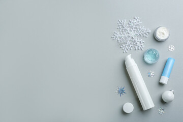 Flat lay composition with different cosmetic products on light grey background, space for text. Winter care