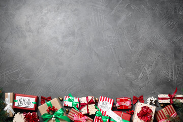 Flat lay composition with Christmas gift boxes on grey background. Space for text