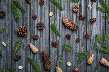 Flat lay composition with pinecones on black wooden background