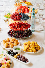 table served with light summer snacks-fruits, vegetables, berries. catering 