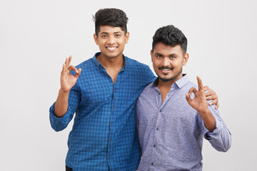 Indian two young  man showing hand sign isolated on white.