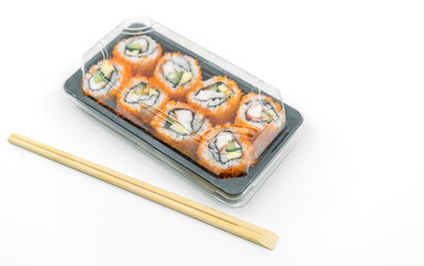 Easy Japanese food, Sushi rolls ready to eat in plastic container with chopsticks, image on white background.