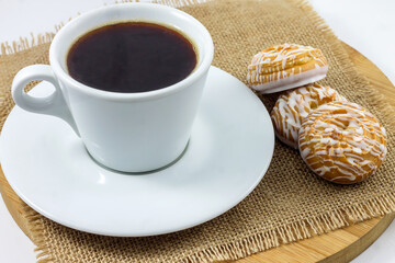 Morning light breakfast. A cup of aromatic black coffee with delicious glazed cookies.