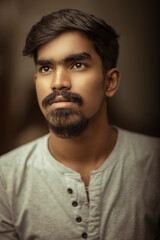 Obraz premium Fine art portrait of handsome young man looking at the light.